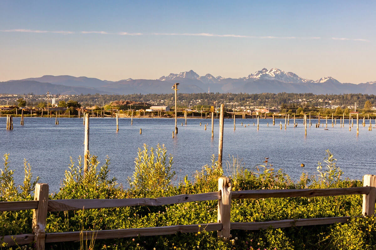 Early morning summer sunrise over the Snohomish from the Bay Wood Nature trail with Marysville in background
